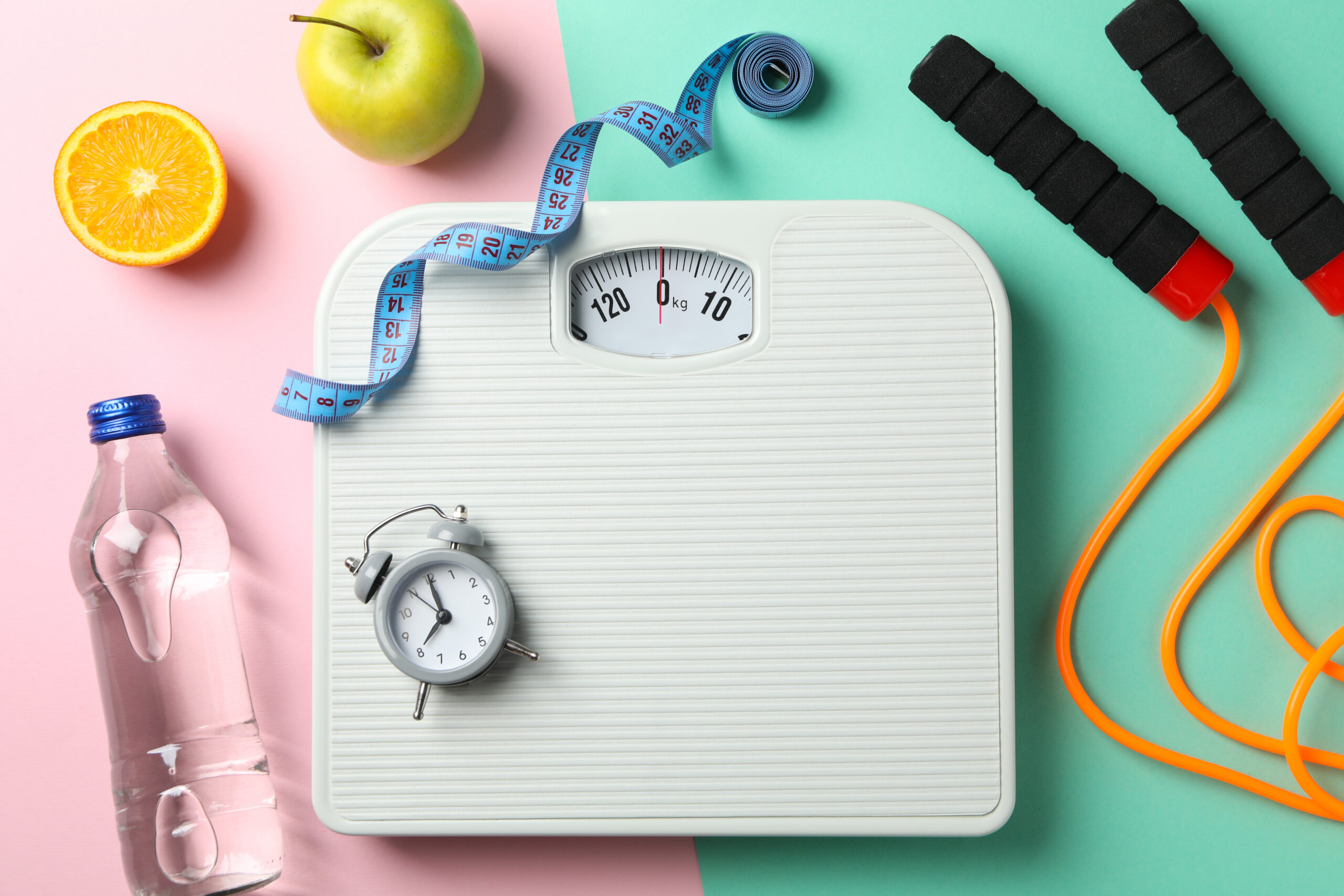 Weight loss and healthy lifestyle accessories on two tone background